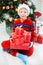 Funny little kid dressed in red night pyjamas and hat of santa