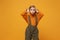 Funny little kid girl 12-13 years old in turtleneck, jumpsuit isolated on orange yellow background in studio. Childhood