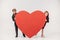 funny little kids couple hiding behind large red heart