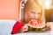 Funny little toddler girl 4 year eating watermelon close-up at home, looking at camera