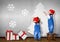 Funny Little twins dressed Santa hat, glue Christmas tree on wal