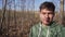 Funny looking young man is walking in country side alone along fields.