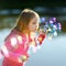 Funny lovely little girl blowing soap bubbles