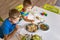 Funny male brothers eat cookies with round multi-colored sweets and drink milk. Top view.