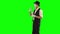 Funny male mime in white and black clothes imitating talking to someone. One actor performing show on green background