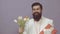 Funny man with bouquet of tulips and gift for birthday. Bearded man holds flowers. Valentines Day. Womens Day. Spring
