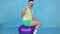 Funny man coach with a mustache from 80`s, on the fitness ball on blue background slow mo