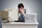 Funny man is covering face and looking on pile of documents on desk. Paperwork concept.