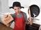 Funny man holding pan with pot on head in apron at kitchen asking for help