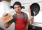 Funny man holding pan with pot on head in apron at kitchen asking for help