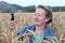 Funny mature woman doing selfie in gorgeous wheat field. 60 years old taking photos of herself