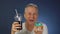 Funny middle-aged man funny eating cake, washing down his carbonated drink from a large glass with a straw.