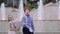 Funny mime and little girl with bouquet of flowers at background of fountains