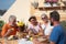 Funny moment for a senior couple of grandparents with son and teenager nephew. Four people enjoying the breakfast sitted around a