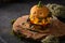 Funny monster chicken burger with salad, tomato, pepper, cutlet, cheese and pumpkin head rolls on baking paper in the form of a