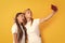 funny mother and daughter making selfie on smartphone, networking