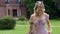 funny mother and daughter in pink dresses in nature on a green meadow in summer and they are photographed by a