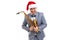 Funny musician wears in Santa& x27;s hat holds saxophone while showing thumb up on studio background