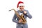 Funny musician wears in Santa& x27;s hat holds saxophone while straightening bow tie on studio background