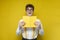 funny nerd guy in glasses holds book and wonders on yellow isolated background, student in festive outfit reads book