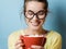 Funny Nerd young woman with a red mug with cocoa and marshmallow