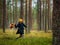 Funny one person searching for a mushrooms in an autumn deep forest. mushroomer with a basket in a woods