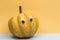 Funny overripe pumpkin with eyes on the orange background