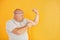 Funny overweight man in sportive head tie is against yellow background