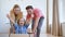 Funny parents lady blonde and bearded guy move large cardboard box with delighted preschooler girl