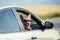 Funny passenger red corgi puppy dog in sunglasses pretty stuck his muzzle out of the car window while traveling summer sunny day