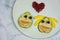 Funny pear couple faces in love with heart shape on a white plate