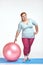 Funny picture of amusing, red haired, chubby woman which is holding a ball