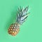 Funny pineapple in heart-shaped glasses on neo mint paper background