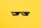 Funny pixelated boss sunglasses on yellow background. Gangster, Black thug life meme glasses . Pixel 8bit style