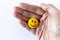 Funny plastic smiley face in a human hand. The concept of a positive mood