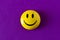 Funny plastic smiley face on a purple background. The concept of a positive mood