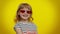 Funny playful blonde kid child wearing sunglasses, blinking eye, looking with charming smile