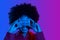 Funny portrait of african woman holding retro music cassette in front, double color neon light