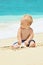 Funny portrait of child playing with sea shell on beach