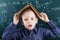 Funny portrait clever pupil boy on school board background