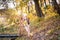 Funny portrait of a little girl. Little girl in a pink hat on a walk in the fall. Child girl in a jacket happily runs and collects