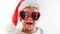 Funny portrait of naughty African American Baby wearing Sunglasses and Santa Hat Screaming Crying