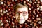 Funny portrait of preteen or school kid boy with glasses with lots of chestnuts. Smiling happy child having fun on