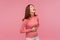 Funny positive brunette woman in pink sweater holding her belly and laughing out loud, excited careless female joking