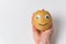 Funny potato with eyes and painted smile is on the hand on white background