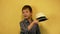 Funny preschool boy gentleman with painted mustache takes off and throws his hat at the camera. A joking greeting with a hat. Sele