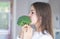Funny preteen girl biting and eating raw broccoli. Diet and healthy food, vegetarian or vegan concept