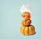 Funny Pumpkin Jack with chef hat on light blue background with copy space, top view. Halloween and Thanksgiving