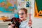 Funny puppi and pupil. Puppy in glasses. Funny pupil looking for a drawing concept. Friendly child in classroom near