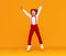 Funny red-haired boy jumps on a yellow background